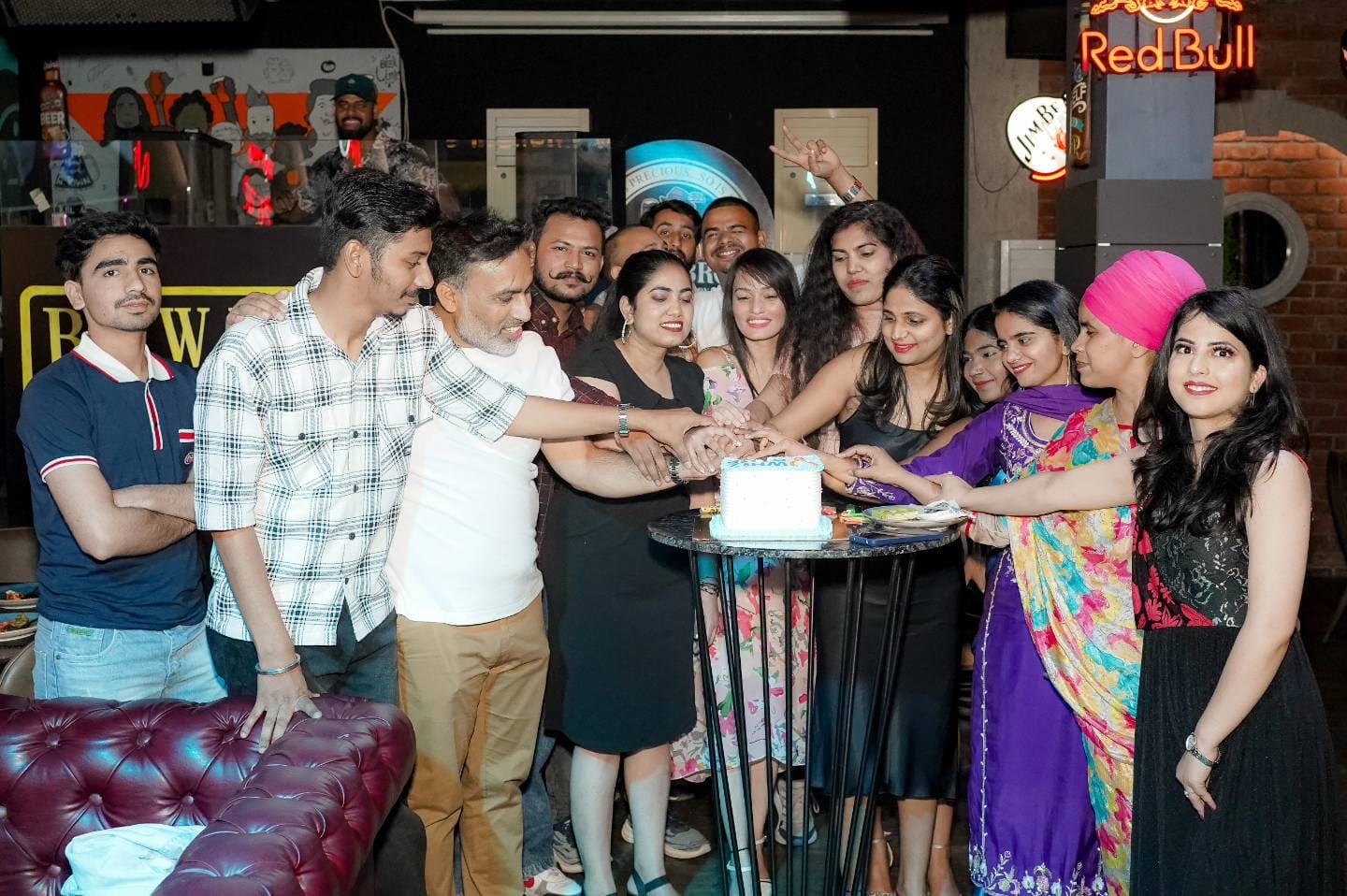 Whizcamp team celebrating a birthday with cake cutting at an office party